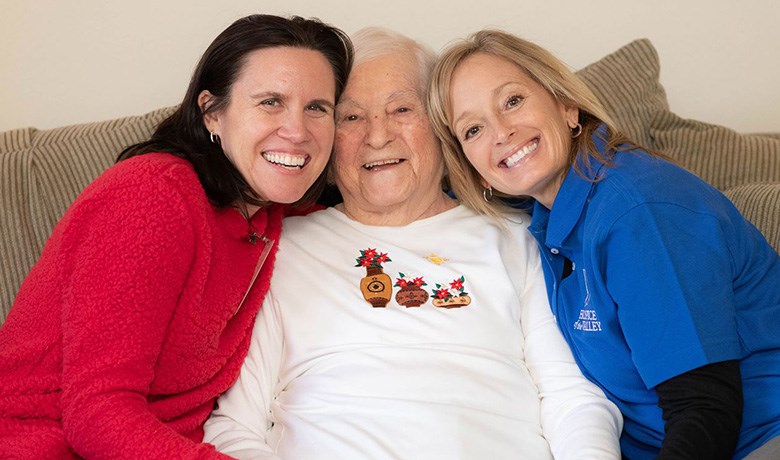 2 nurses with happy female patient sitting in the middle