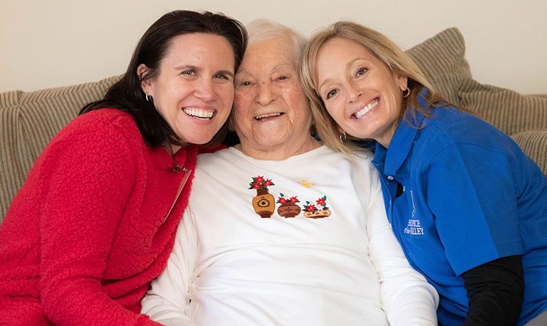 2 nurses with happy female patient sitting in the middle